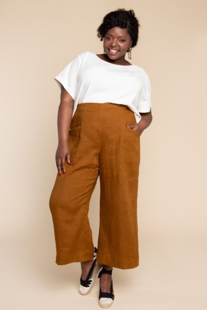 Woman wearing the Pietra Pants sewing pattern by Closet Core Patterns. A trouser pattern made in linen, chambray, lightweight denim or twill fabric featuring a flat front, high waist with elastic at the back and slanted hip pockets.