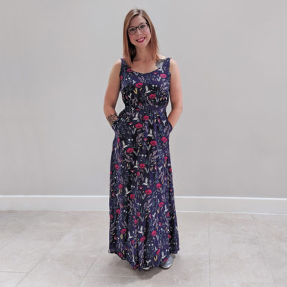 Woman wearing the Rosalee Dress sewing pattern by Experimental Space. A sleeveless dress pattern made in rayon, viscose, crepe, cotton lawn or satin and silk fabrics, featuring a maxi length, deep back and a pretty cutout on the lower back, scoop neckline and pockets.