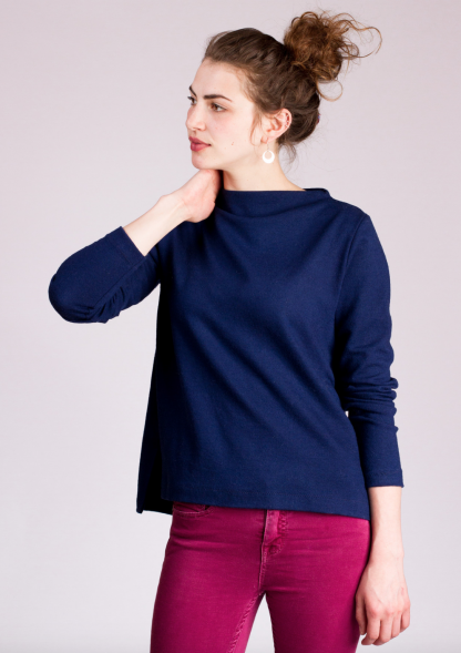 Woman wearing the Toaster Sweaters sewing pattern from Sew House Seven on The Fold Line. A sweater pattern made in mid to heavy weight stretch fabrics, featuring a funnel boat neckline, mitred side vents, high-low he, relaxed fit and full length sleeves.