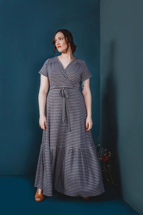 Woman wearing the Westcliff Dress sewing pattern by Friday Pattern Company. A tiered dress pattern made in knit or jersey fabric featuring a full coverage wrap front, short sleeves and front waist tie.