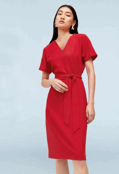 Woman wearing the Mai Tai Dress sewing pattern from Our Lady of Leisure on The Fold Line. A dress pattern made in poplin, crepe de chine or satin fabrics, featuring waist ties, V-neck, grown-on sleeves, knee length, short sleeves, and hem slits.
