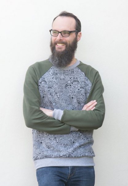 Man wearing the Men’s Dean Sweatshirt sewing pattern by Bobbins and Buttons. A sweatshirt pattern made in medium weight sweatshirt fabric, featuring a raglan sleeve, round neck and ribbed neck, cuff and hem bands.