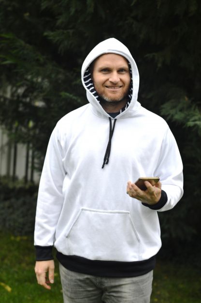 Man wearing the Halftime Hoodie sewing pattern from 5 out of 4 Patterns on The Fold Line. A hoodie pattern made in knit fabric such as medium or heavy weight cotton or poly/cotton blend sweatshirt fabric or heavy french terry, featuring full length sleeves, kangaroo pockets, hood with drawstring closure, ribbed cuffs and waistband.
