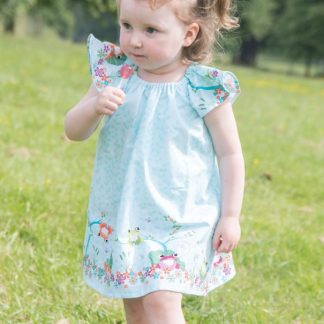 Child wearing the Baby/Child Lillia Rae Dress sewing pattern by Bobbins and Buttons. A dress pattern made in cotton and cotton blends, broadcloth or cotton lawn fabrics, featuring a loose fit, flutter sleeves and elastic neckline.