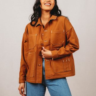 Woman wearing the Unisex Ilford Jacket sewing pattern from Friday Pattern Company on The Fold Line. A jacket pattern made in light to heavyweight woven fabrics, featuring drop shoulders, placket sleeve with cuff, patch pockets, button front closure and hip length finish.