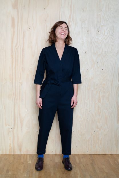 Woman wearing the V-Neck Jumpsuit sewing pattern by The Assembly Line. A relaxed fitting jumpsuit pattern made in tencel, denim, twill or needlecord fabric featuring a V-neck, snap front closure and three quarter sleeves.