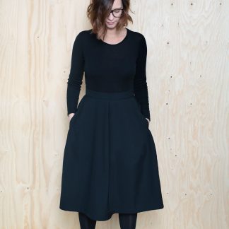 Woman wearing the Tulip Skirt sewing pattern by The Assembly Line. A tulip shaped skirt pattern made in tencel, twill, denim, or wool fabric featuring back zipper opening and in seam pockets.