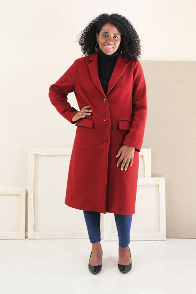 Woman wearing the Chaval Coat sewing pattern from Liesl + Co on The Fold Line. A coat pattern made in wool coating, tweed, canvas, denim, and twill fabrics, featuring a full lining, back walking vent, two-piece full length sleeves, notched collar with banana stand, double-piped front pockets with flaps, button front closure and below knee length.