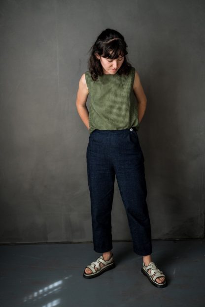 Woman wearing the Eve Trousers sewing pattern by Merchant and Mills. A trouser pattern made in cotton twill, denim, corduroy, woollens or linen fabric featuring a side zip, two back pockets, cropped length, slightly tapered shape and turn ups.