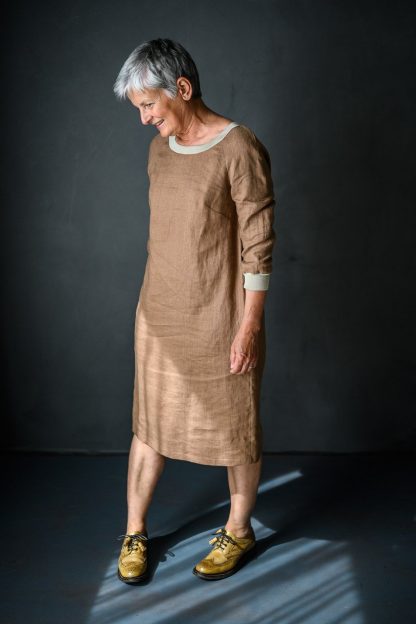 Woman wearing the Fielder Dress and Top sewing pattern by Merchant and Mills. A dress pattern made in linen, cottons, lightweight denims, wools or crepe fabric featuring a round neck, bust darts, three quarter raglan sleeves and in-seam pockets.