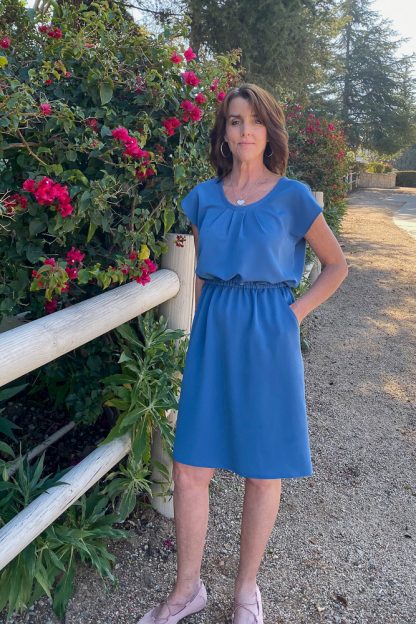 Woman wearing the Morrison Dress sewing pattern by Blue Dot Patterns. A dress pattern made in lightweight wovens such as woven challis and crepe or stable knits such as interlock, jersey or ponte fabrics, featuring a scoop neck, pleated bodice, elastic waist and side pockets.