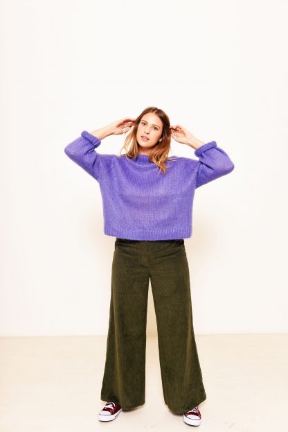Woman wearing the Bertha Trousers sewing pattern from Fibre Mood on The Fold Line. A trousers pattern made in wide-wale or pincord cotton corduroy, light wool (with a checked pattern) or denim (cotton) fabrics, featuring a high-waist, wide straight legs and fly front zipper.