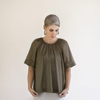 Woman wearing the Calyx Smock sewing pattern from Pattern Fantastique on The Fold Line. A top pattern made in woven fabrics, featuring a gathered neckline, relaxed fit, and tie closure at the centre back.