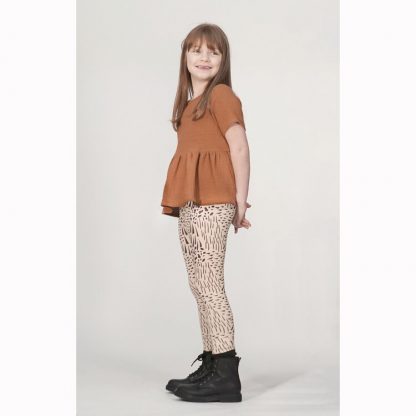 Child wearing the Child Roux Legging sewing pattern from Pattern Paper Scissors on The Fold Line. A leggings pattern made in jersey, knit, or cotton elastane fabrics, featuring an elasticated waist, and full-length leg.