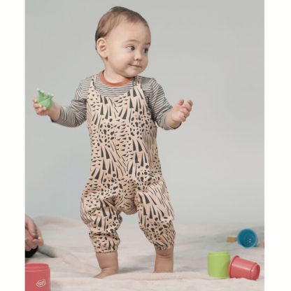 Toddler wearing the Babies' Avery Romper sewing pattern from Pattern Paper Scissors on The Fold Line. A romper pattern made in jersey, sweat, terry, stretch crepe, or knit fabrics, featuring elasticated ankle cuffs, relaxed fit, and shoulder straps.