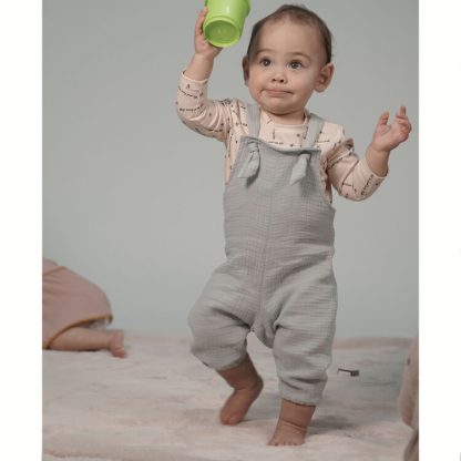 Toddlers wearing the Florrie Woven Romper sewing pattern from Pattern Paper Scissors on The Fold Line. A romper pattern made in cotton, viscose, denim, double gauze, linen or crepe fabrics, featuring an ankle length, relaxed fit, bib, and adjustable tie straps.