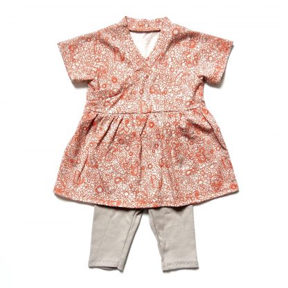 The Babies' Flo Dress and Riley Leggings sewing pattern by Dhurata Davies Patterns. A dress and leggings pattern made in lightweight cotton jersey fabric, featuring a short sleeved, V-neck dress and leggings with an elasticated waist.