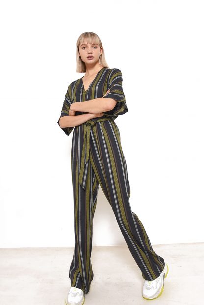 Woman wearing the Riva Jumpsuit sewing pattern from Fibre Mood on The Fold Line. A jumpsuit pattern made in viscose, crepe or viscose twill fabrics, featuring a V-neck wrap top, shaped 3/4 grown on sleeves, elasticised waist, self-fabric belt, wide trouser legs and relaxed fit.