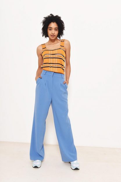 Woman wearing the Peaches Trousers sewing pattern from Fibre Mood on The Fold Line. A trouser pattern made in crepe, linen or cotton fabrics, featuring front pleats, high-waist, wide-legged, side pockets and back welt pockets.
