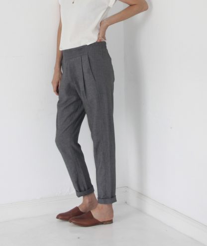 Woman wearing the Calyer Pants sewing pattern by French Navy. A trouser pattern made in medium weight knit fabrics, featuring a pleated front, slightly dropped crotch, semi-elasticated waistband, in-seam pockets and tapered leg.