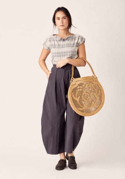 Woman wearing the Arthur Pants sewing pattern by Sew Liberated. A trouser pattern made in linen, gabardine, silk noil, twill, cotton chambray, French terry, interlock or jersey fabrics, featuring wide-legs with dramatically shaped side seams and a tapered hem, high waist, lowered crotch, roomy pockets and zipper fly.