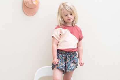 Child wearing the Child/Teen Steph Shorts sewing pattern from WISJ Designs on The Fold Line. A bag pattern made in viscose, bamboo jersey, or crepe fabrics, featuring a high-low hem, very wide legs, and elastic waist.
