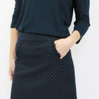 Woman wearing the Novembre Skirt sewing pattern by Atelier Scammit. A skirt pattern made in medium to heavy woollens or jacquard fabrics, featuring a short A-line style and in-seam pockets.