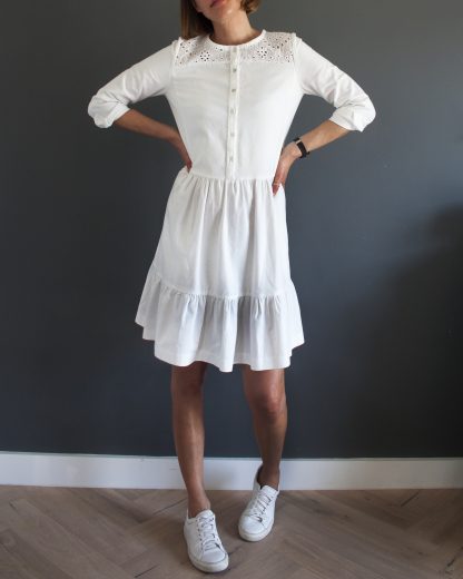 Woman wearing the Fleetwood Dress sewing pattern by French Navy. A dress pattern made in light to medium weight woven fabrics, featuring a button-up bodice, gently shaped side panels, front and back yokes, ¾ length sleeves and a two tiered skirt.