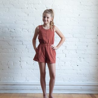 Girl wearing the Children’s Mini Nova Jumpsuit sewing pattern by True Bias. A sleeveless jumpsuit pattern made in light to medium knit fabrics fabric featuring a wide elastic waistband, inseam pockets and a round neck.