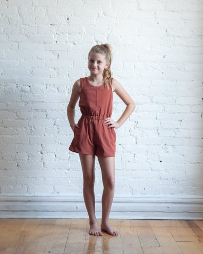 Girl wearing the Children’s Mini Nova Jumpsuit sewing pattern by True Bias. A sleeveless jumpsuit pattern made in light to medium knit fabrics fabric featuring a wide elastic waistband, inseam pockets and a round neck.