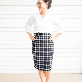 Woman wearing the Pleated Pencil Skirt sewing pattern by Delia Creates. A pencil skirt pattern made in suiting, chambray, linen, corduroy or wool, fabrics, featuring a closed kick pleat, high waist, knee length and invisible side zipper.