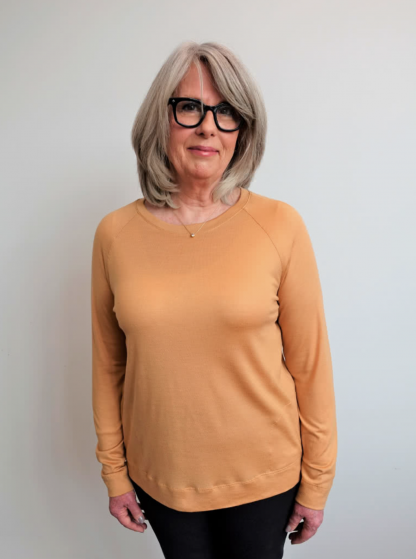 Woman wearing the Preston Knit Sweater sewing pattern from Style Arc on The Fold Line. A jumper pattern made in knit jersey or baby wool fabrics, featuring a squarish silhouette, crew neck, raglan sleeves and in-seam pockets.