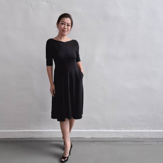 Woman wearing the Asta Dress sewing pattern from Wardrobe by Me on The Fold Line. A dress pattern made in medium to heavyweight jersey fabrics, featuring a fitted bodice, slightly flared four-gore skirt, patch pockets, boatneck, knee length and elbow length sleeves.