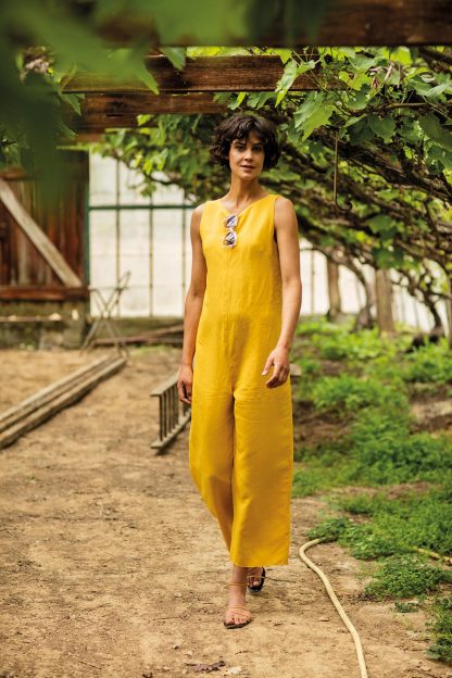 Woman wearing the Danika Jumpsuit sewing pattern from Fibre Mood on The Fold Line. A jumpsuit pattern made in linen, cotton, chambray, viscose (crepe), polyester crepe, or Tencel fabrics, featuring a low tie back opening, round neck, bust darts, relaxed fit and cropped length hem.