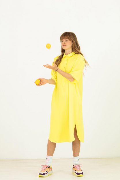 Woman wearing the Franca Dress sewing pattern from Fibre Mood on The Fold Line. A shirt dress pattern made in viscose (crepe), polyester (crepe), cotton, satin, linen or Tencel fabrics, featuring a mid-length hem, curved side slits, polo collar, back yoke and short inset sleeves.