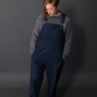 Woman wearing the Harlene Dungarees sewing pattern by Merchant and Mills. A dungaree pattern made in denim, cotton canvas, corduroy, or linen fabric featuring five pockets, top stitching and an easy fit.