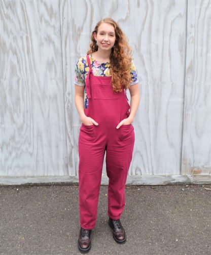 Woman wearing the Lazy Day Dungas sewing pattern from Stitched in Wonderland on The Fold Line. A dungaree pattern made in cotton poplin, denim, corduroy, linen or canvas fabrics, featuring adjustable shoulder straps, chest patch pocket, front and back patch pockets, side zip and tapered legs.