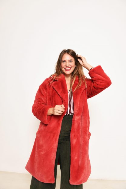 Woman wearing the Roma Coat sewing pattern from Fibre Mood on The Fold Line. A coat pattern made in faux fur, teddy bear, checked wool, flannel or cashmere blend fabrics, featuring a roomy fit, revere collar, pockets, front snap closure and knee length.