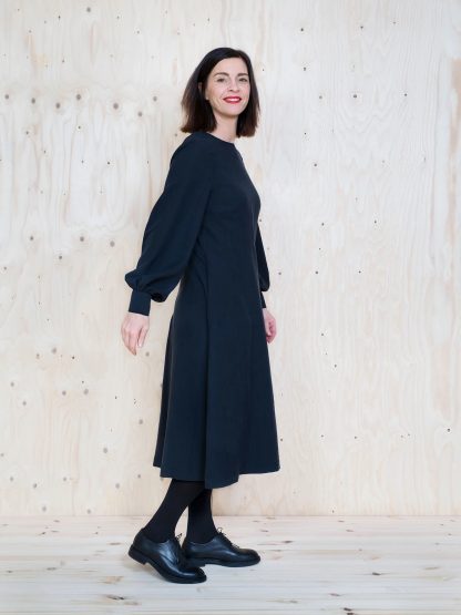 Woman wearing the Multi-Sleeve Midi Dress sewing pattern by The Assembly Line. A dress pattern made in light to medium weight fabrics such as, cotton, tencel, silk, linen, crepe de chine or wool crepe fabrics, featuring an A-line silhouette, round neck, concealed back zipper, in-seam pockets and a puff long sleeve.