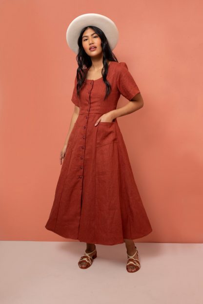 Woman wearing the Hughes Dress sewing pattern from Friday Pattern Company on The Fold Line. A dress pattern made in rayon, silk or linen fabrics, featuring Viennese seams, gathered sleeves, scoop neckline, lined bodice, A-line skirt, button front closure, front pockets and adjustable lace-up tie in the back.