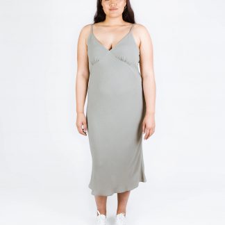 Woman wearing the Maya Dress sewing pattern from Papercut Patterns on The Fold Line. A cami dress pattern made in crepe de chine, rayon or silk fabrics, featuring a bias cut, spaghetti straps, deep V-neckline, gathered bust cup, and midi length.
