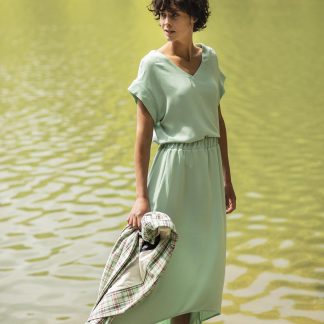 Woman wearing the Betsy Skirt sewing pattern from Fibre Mood on The Fold Line. A skirt pattern made in woven or knit fabrics, featuring an elasticised waist, high-low hem, calf-length hem and relaxed fit.