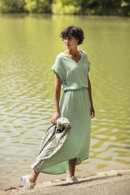 Woman wearing the Betsy Skirt sewing pattern from Fibre Mood on The Fold Line. A skirt pattern made in woven or knit fabrics, featuring an elasticised waist, high-low hem, calf-length hem and relaxed fit.
