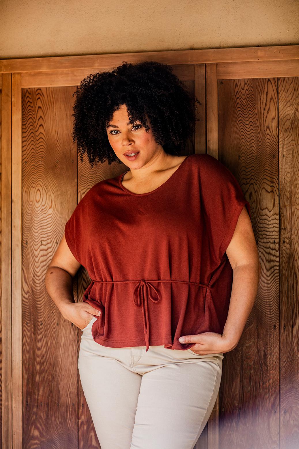 Woman wearing the Clara Top sewing pattern from Fibre Mood on The Fold Line. A knit top pattern made in Jersey fabrics, featuring a round neckline, cap sleeves and relaxed fit.