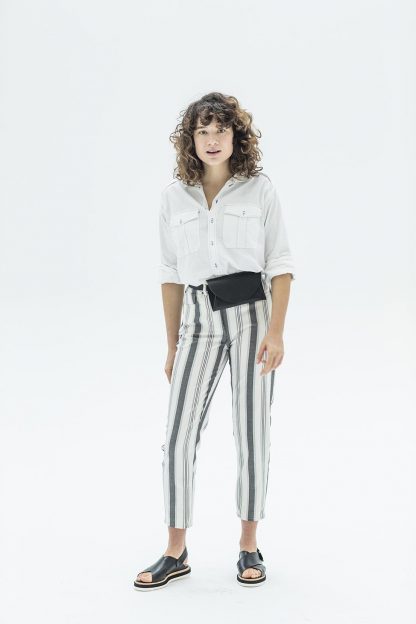 Woman wearing the Ebony Trousers sewing pattern from Fibre Mood on The Fold Line. A trouser pattern made in cotton/denim twill fabrics, featuring a high waist, loose tapered cut, cropped length, back patch pockets, front jeans pockets and button fly.