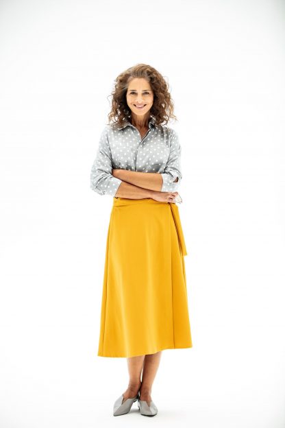 Woman wearing the Ginny Skirt sewing pattern from Fibre Mood on The Fold Line. A wrap skirt pattern made in suede, satin, viscose, soft faux leather, interlock, French terry or fine knit fabrics, featuring a midi length, waist band and waist tie.