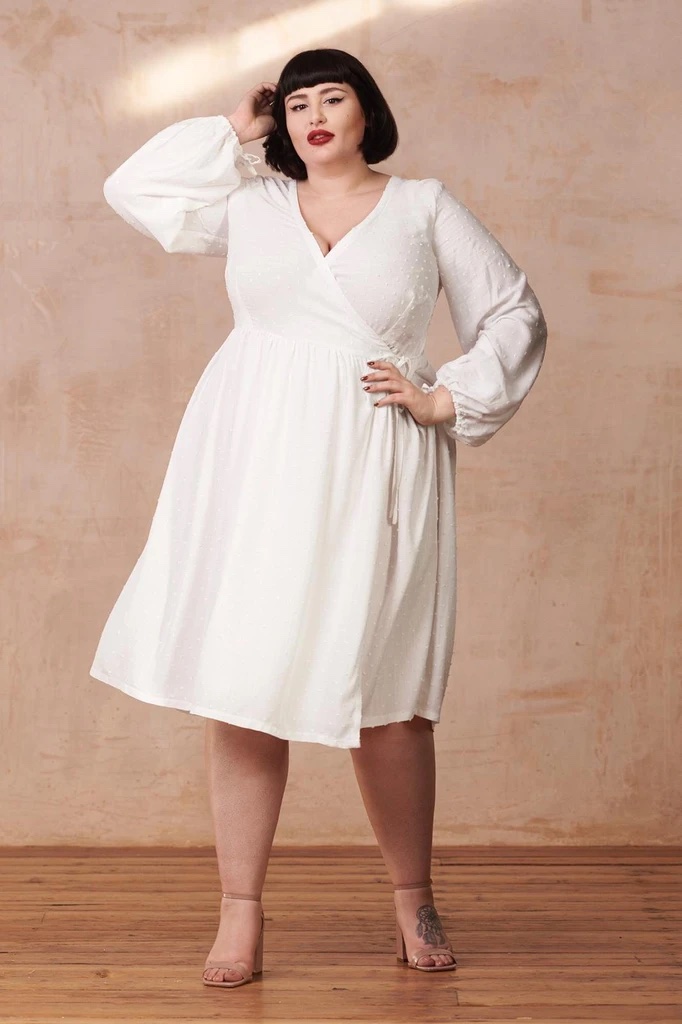 Woman wearing the Hannah Dress sewing pattern from By Hand London. A wrap dress pattern made in cottons, linens or viscose fabrics, featuring a scoop wrap neckline, gently gathered skirt and long sleeves.