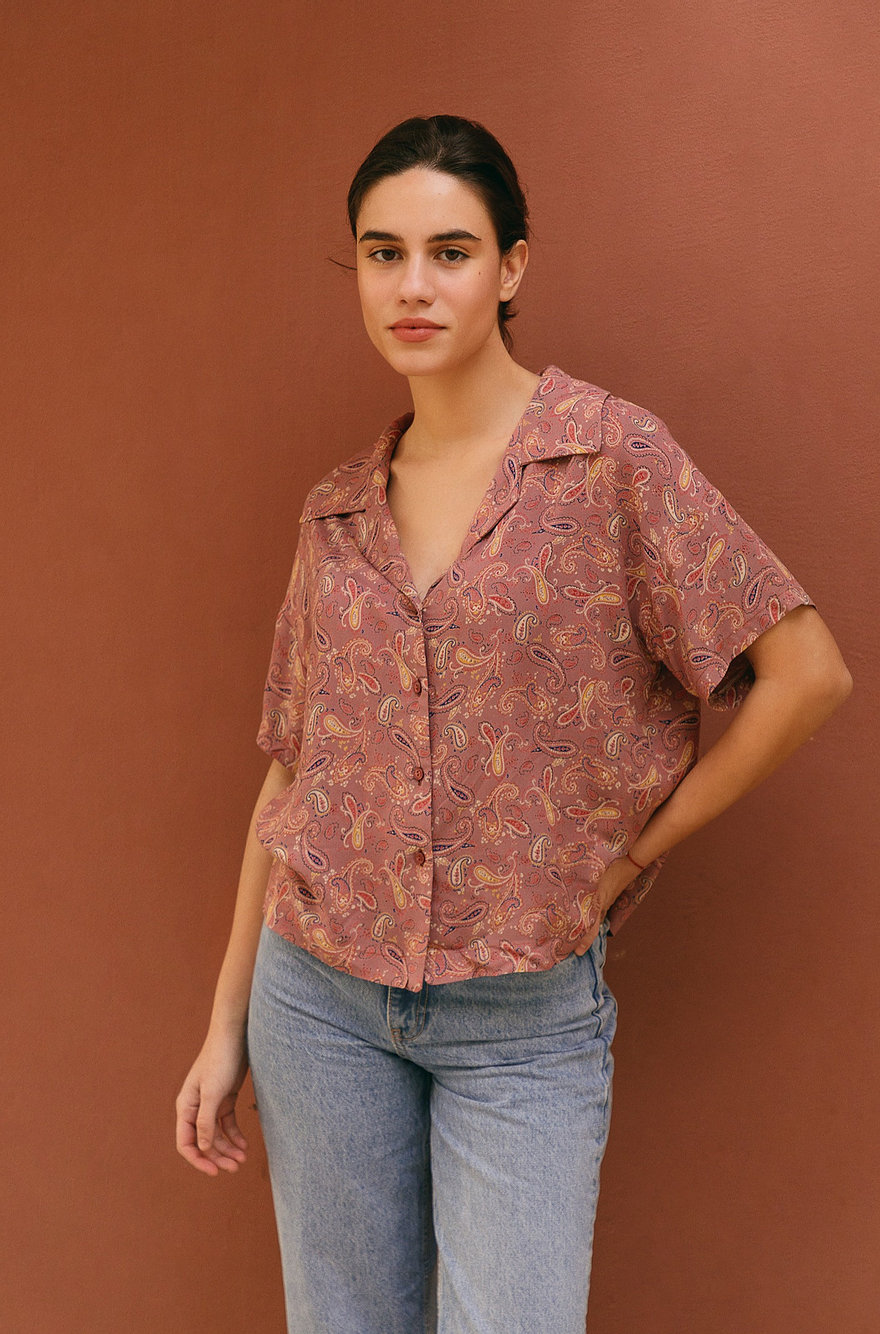 Woman wearing the Lucy Shirt sewing pattern by The Patterns Room. A shirt pattern made in poplin, linen, viscose or silk fabrics, featuring an oversized, boxy fit, notch collar, button up front, back yoke, dropped shoulders and short sleeves.