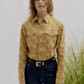 Woman wearing the Unisex Camargue Cowboy Shirt sewing pattern by Liberty Sewing Patterns. A shirt pattern made in cotton, or chambray fabrics, featuring a classic shirt collar, long sleeves with button cuffs, patch chest pockets and button front closure.