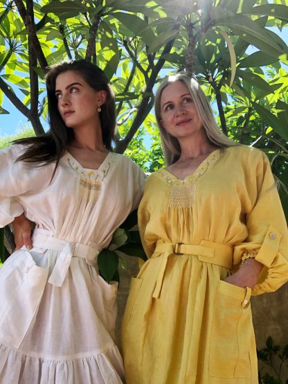 Women wearing the Edith Smock sewing pattern by Pattern Union. A dress pattern made in linen, voiles, satin, or velvet fabrics, featuring a smock style, belt, pockets with button tab detail, full sleeves with button tabs, V-neck and embroidery on the neckline and belt.